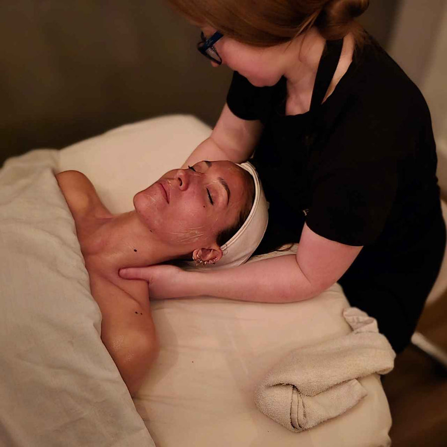 esthetician giving a client a relaxing shoulder massage during a facial treatment at silhouette spa