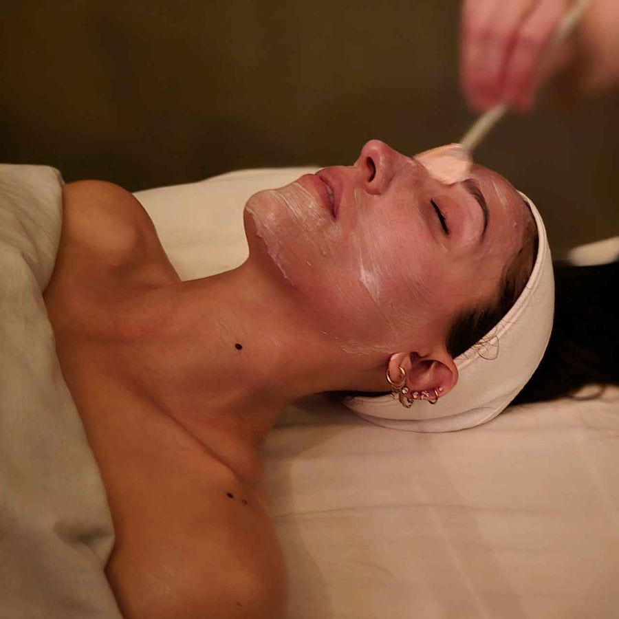 spa therapist applying a hydrating facial mask with a soft brush to a client at silhouette spa