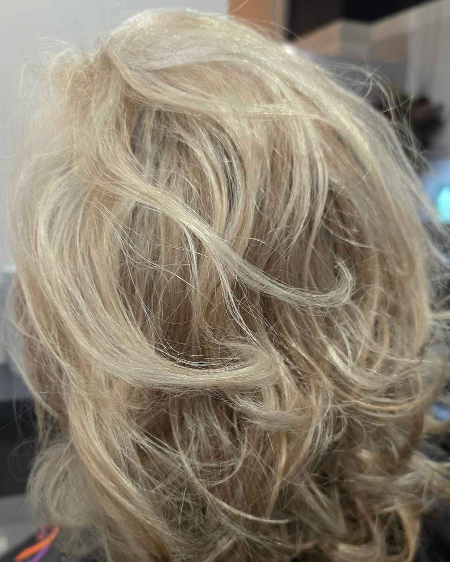close up view of a bright platinum blonde short layered haircut styled with soft piecey texture at silhouette spa hair salon